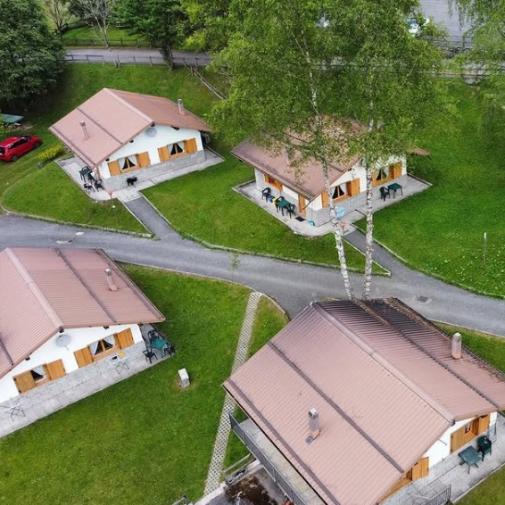 Cottage immersi nel verde con tetti marroni e vialetti collegati.