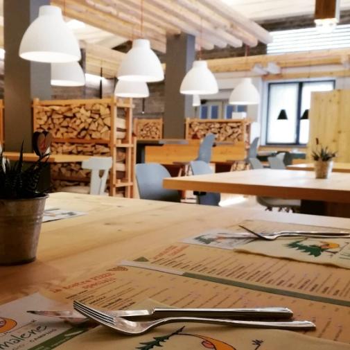 Ristorante accogliente con arredamento in legno e atmosfera calda, menu sul tavolo.